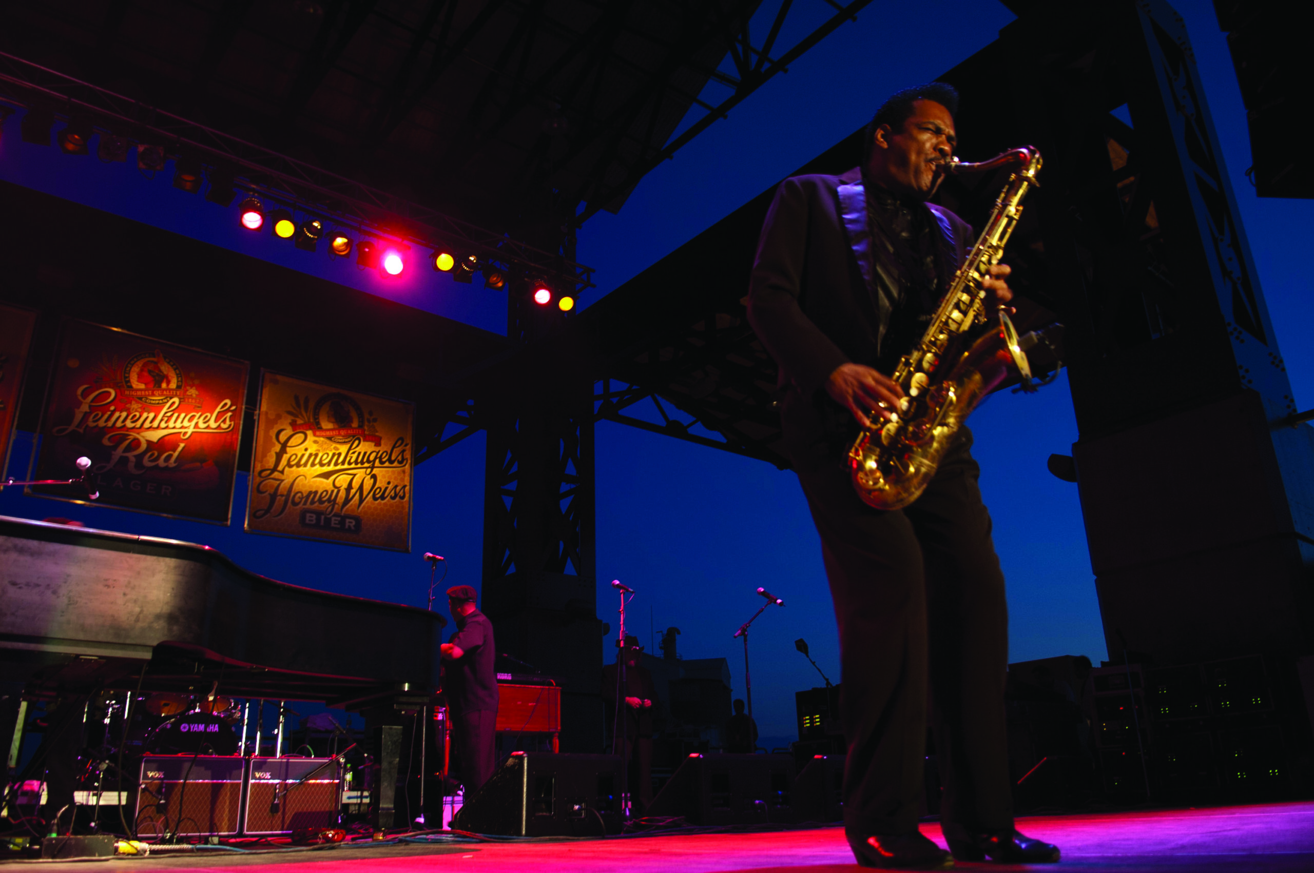 A man playing the saxophone on a lit purple stage at Bayfront Park in Duluth