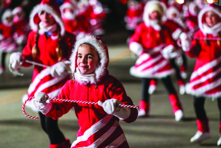 Christmas City of The North Parade with a group of young dancers dressed in red and white candy cane outfits.