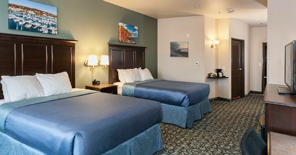 A hotel room at Park Point Marina Inn, in Duluth, MN, with two queen size beds, with Lake Superior blue blankets.