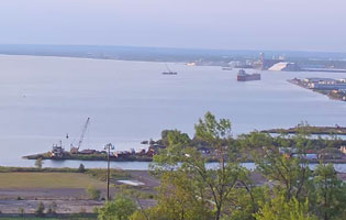 A distant view of the Duluth Superior Harbor with a ship and dredging machines