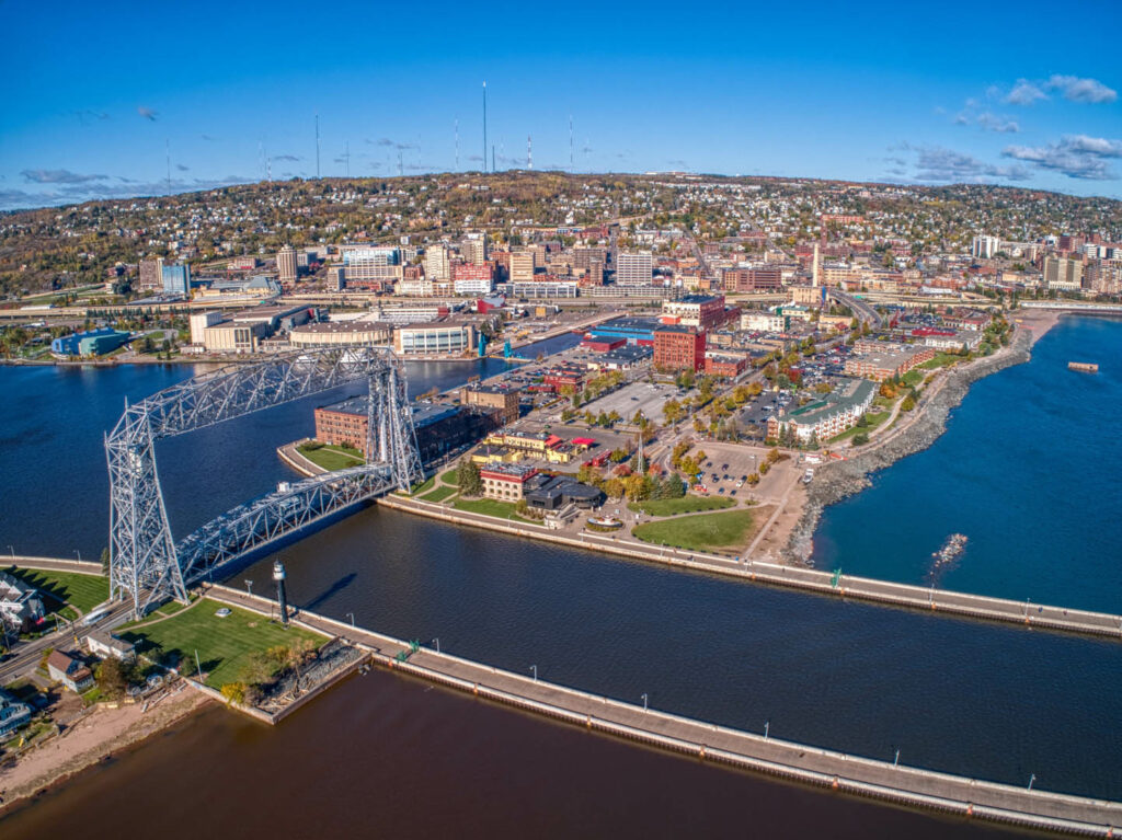 A drone view of the aerial lift bridge, canal park, downtown duluth and central hillside.