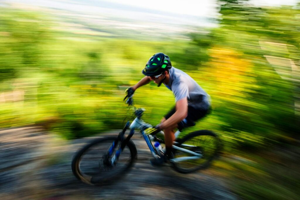 Mountain biker going fast. Blurred background.