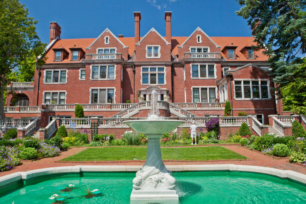 Glensheen's facade facing Lake Superior with the fountain in the extreme front. The fountain water is green.