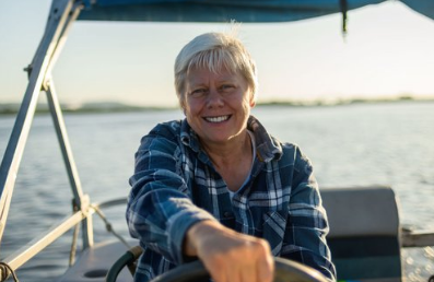 Senior woman driving a pontoon boat.