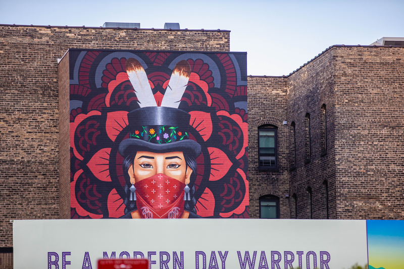 Ganawenjige Onigam, a mural depicting an Ojibwe dancer watching over the city