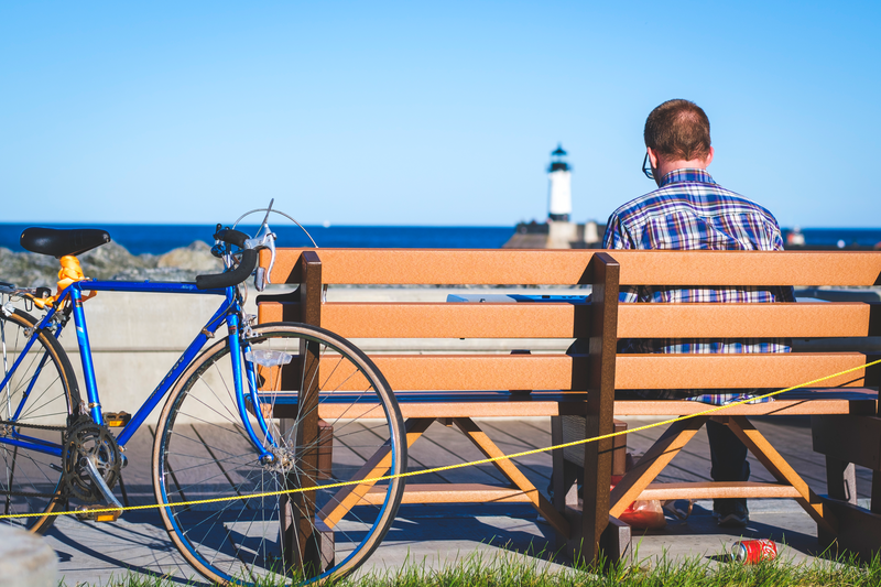 person sitting on a bench with a bike