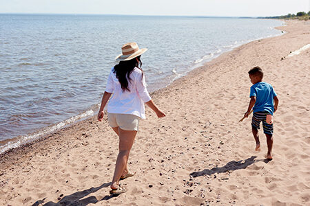 mom and son walking on the beach