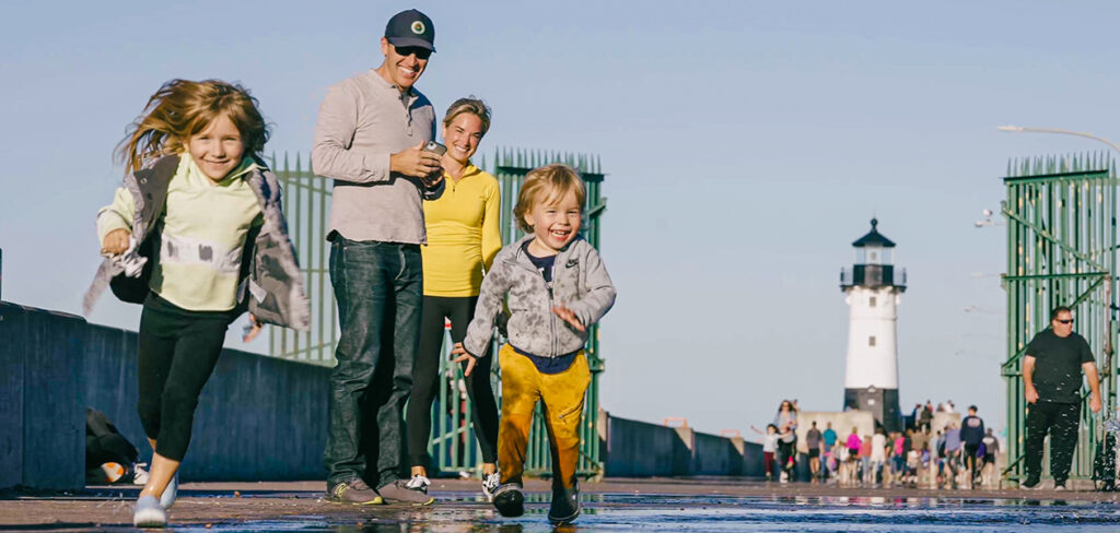 parents watching their children run through a puddle