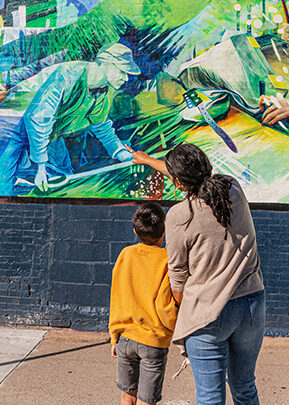 people admiring a mural