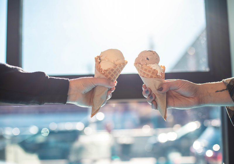 two people cheersing ice cream cones