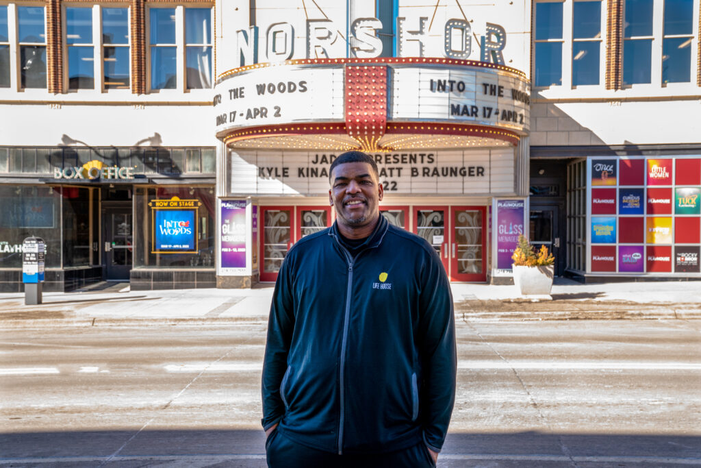 Gabe Mayfield smiles in front of the NorShor Theater