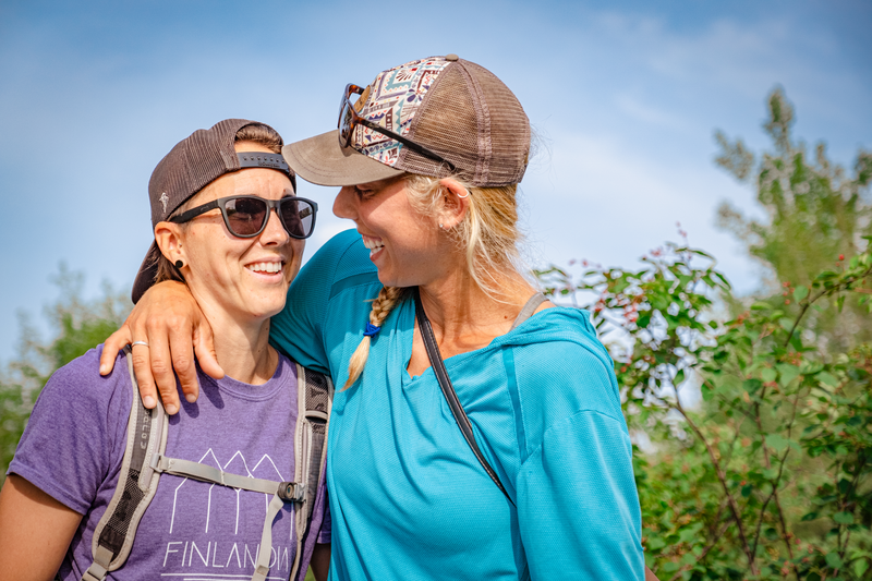 a couple smiles at each other while hiking