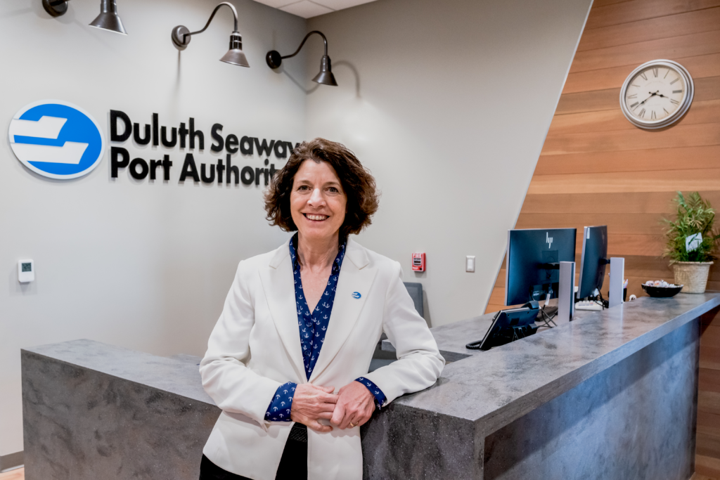 Deb DeLuca stands in front of the Duluth Seaway Port Authority office front desk.