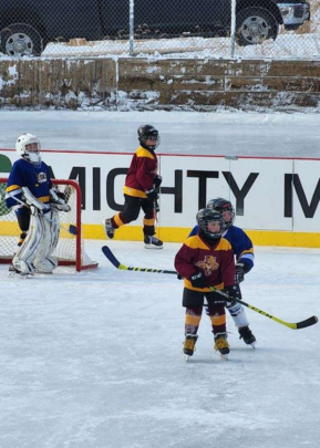 kids playing hockey on outdoor ice rink