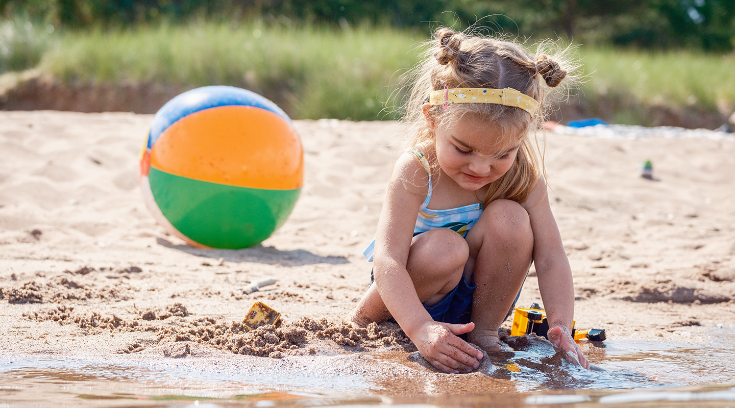 a little girl playing in the sand
