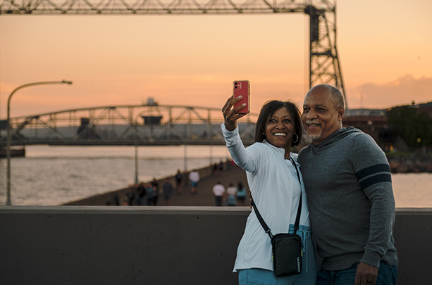 A couple taking a selfie in front of the Aerial Lift Bridge