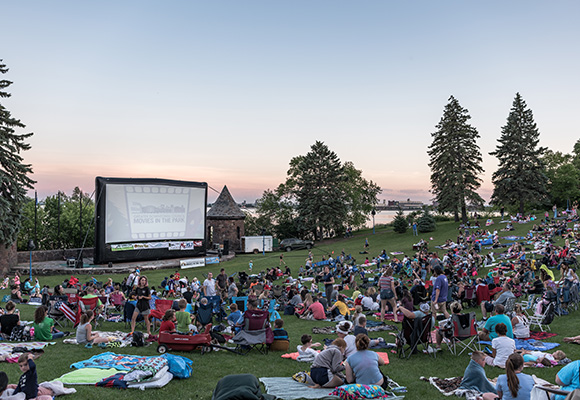 Large group of people watching a movie in a park