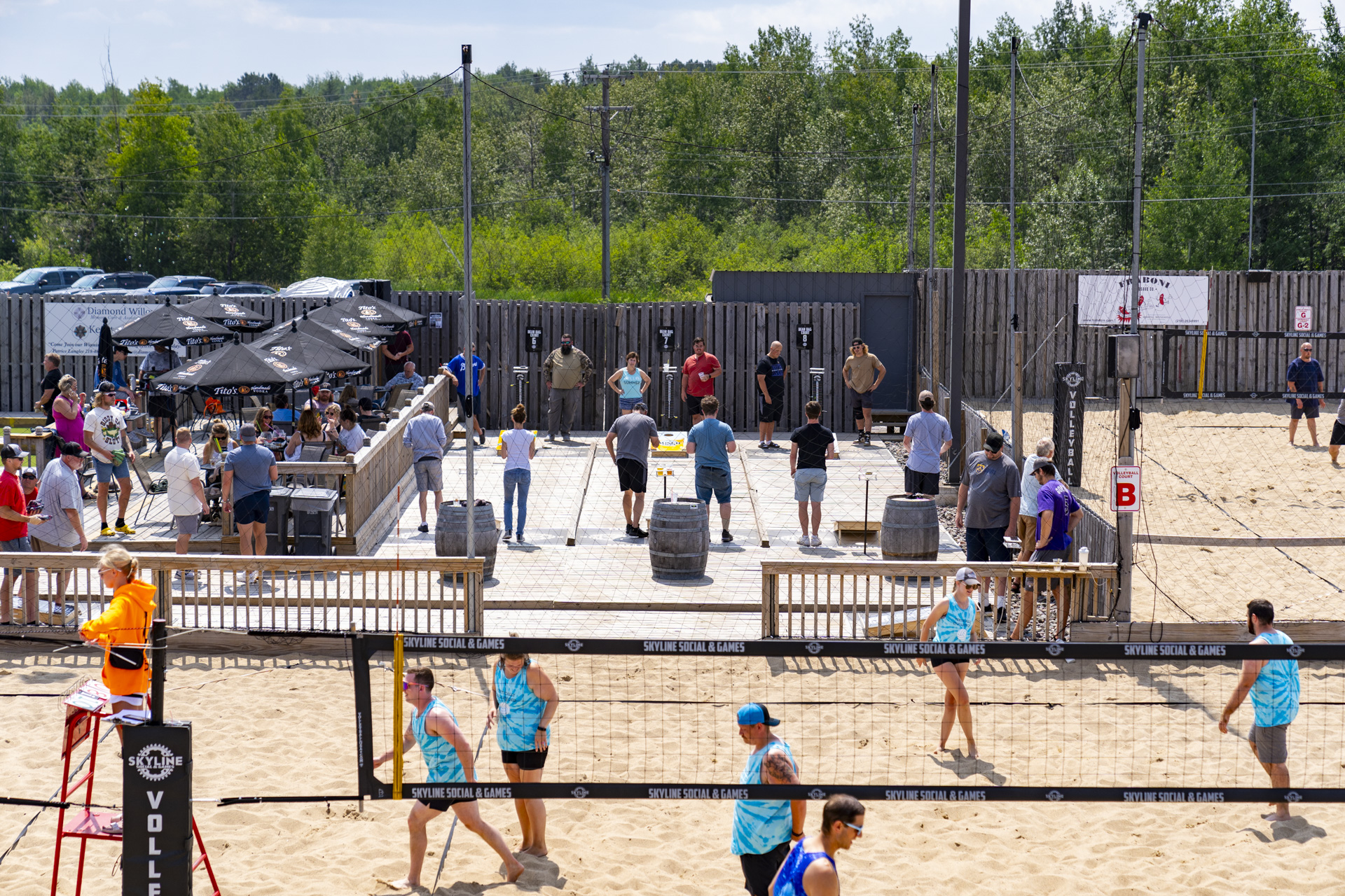 people playing sand volleyball and bean bags