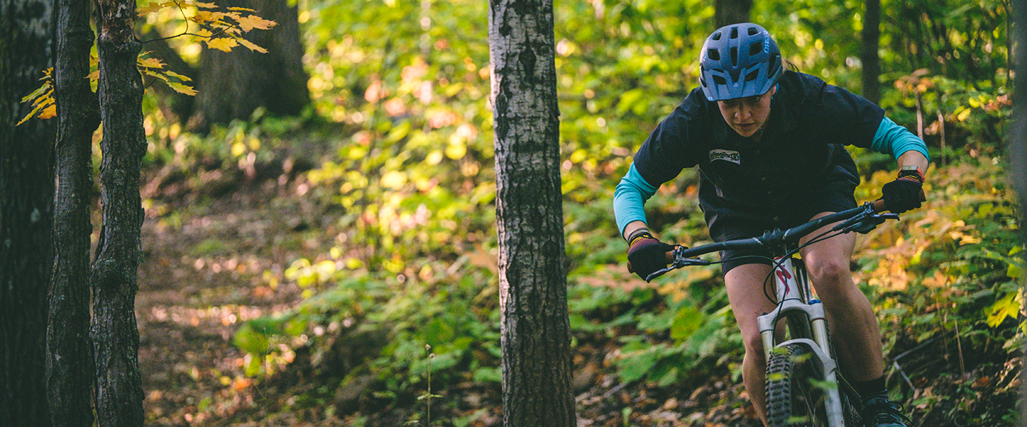 person biking in the woods