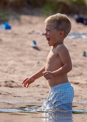 Boy playing in Lake Superior at Park Point Beach