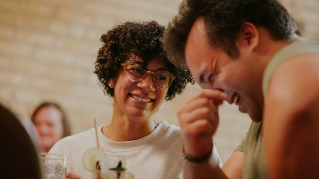 two people enjoying beverages and laughing