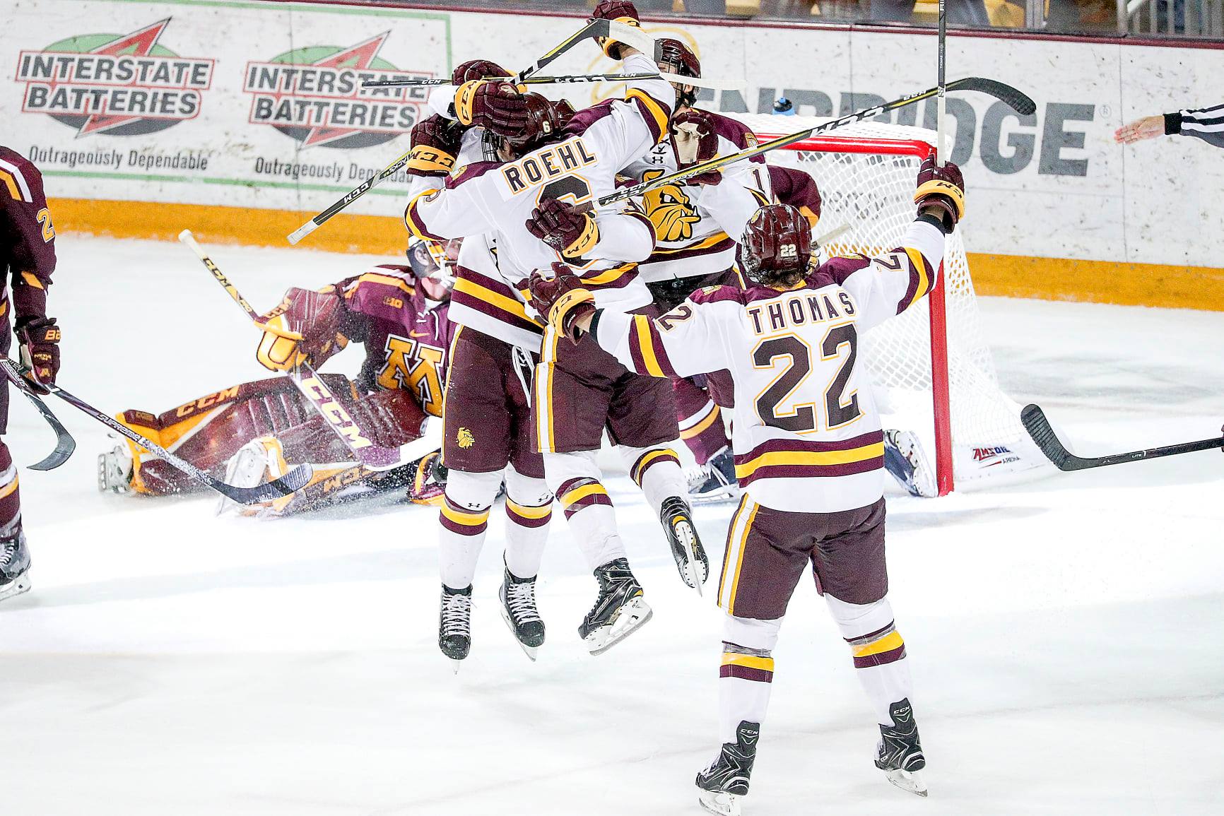 Umd bulldogs men's hockey players celebrating a goal on the ice at amsoil arena in duluth