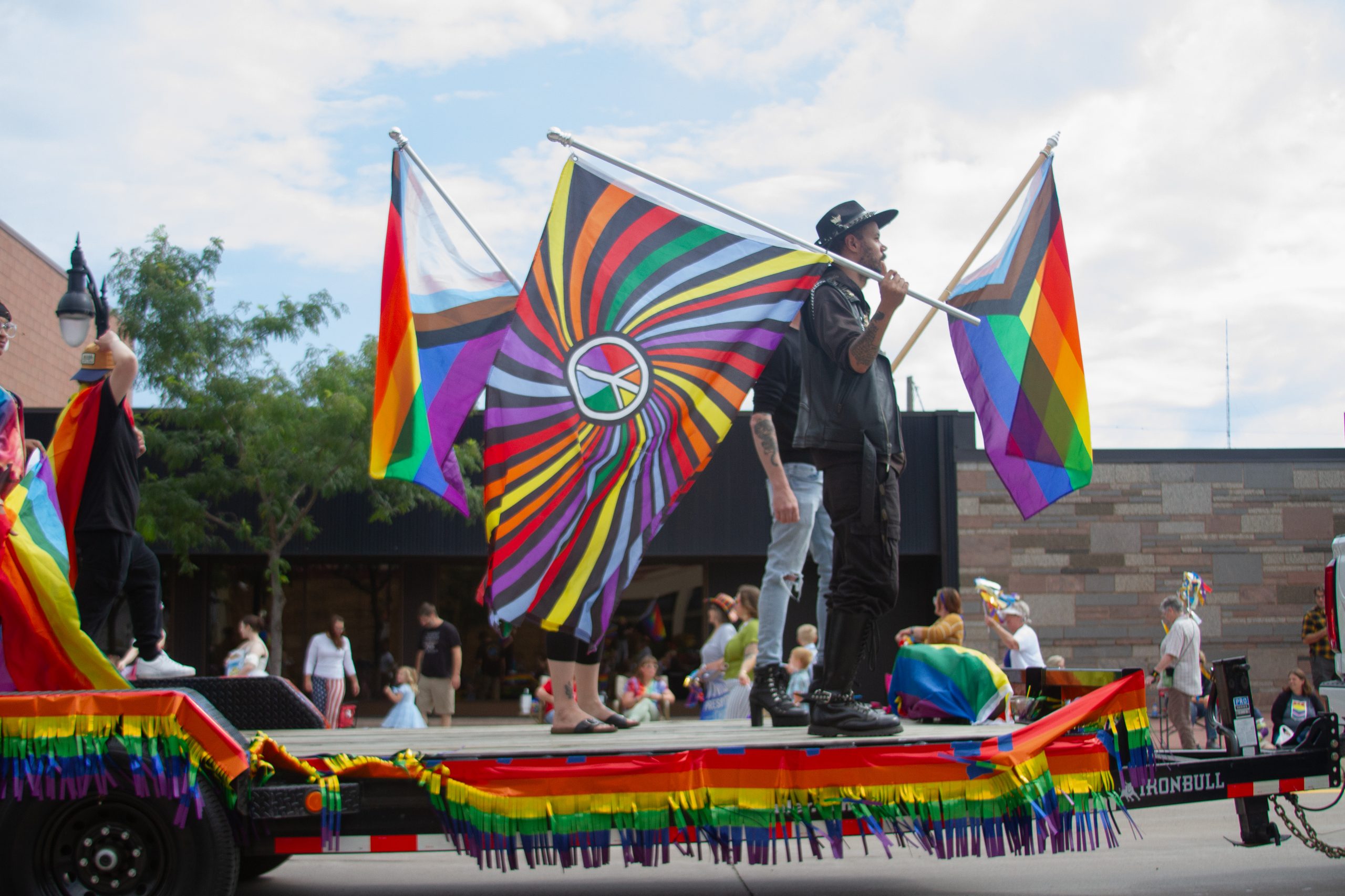 People celebrating with rainbow flags during duluth-superior pride festival parade.