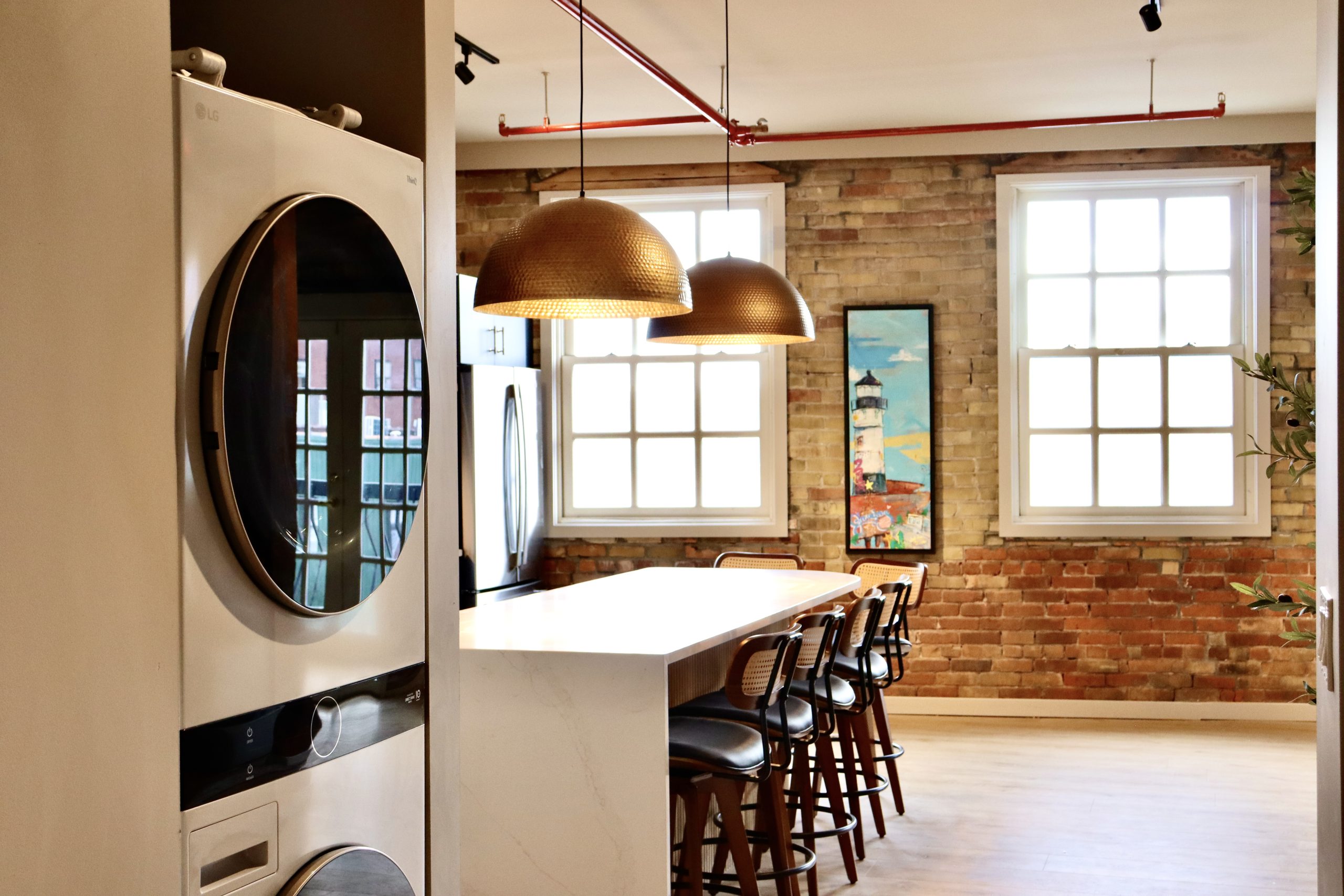 The brix: a different kind of stay in duluth 4 Loft condo interior with in-unit laundry, exposed brick walls, and a kitchen island.