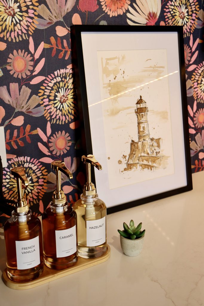 The brix: a different kind of stay in duluth 8 Coffee station detail at the brix aerial lofts featuring gourmet syrup dispensers, floral wallpaper, and a framed lighthouse art print in duluth, mn.