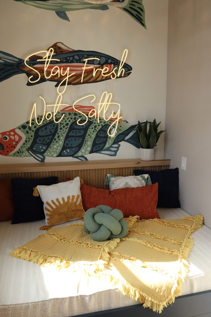 The brix: a different kind of stay in duluth 2 Cozy bed nook in a boutique condo featuring a stay fresh not salty neon sign and custom fish mural.