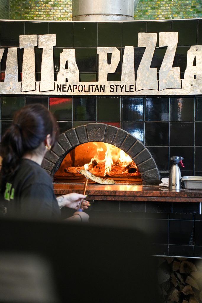 How vitta pizza became a duluth favorite 11 A staff member placing a pizza into the fiery wood-fired oven at vitta pizza in duluth.