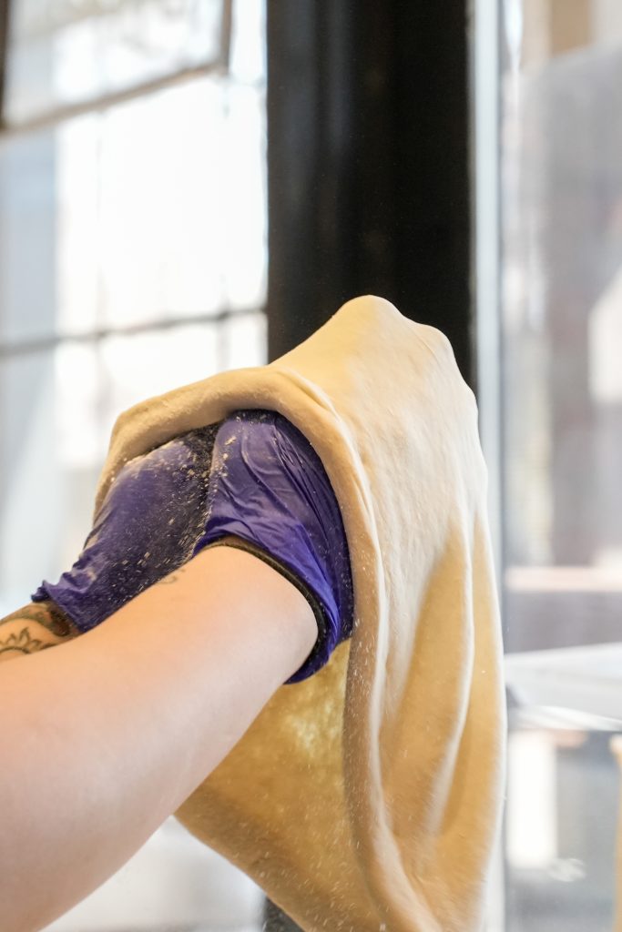 How vitta pizza became a duluth favorite 3 Baker stretching fresh pizza dough by hand for an authentic neapolitan crust.