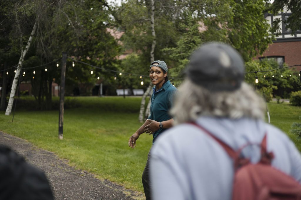 Insights from glensheen’s gardens with head gardener emily ford 12 Head gardener emily ford talks with visitors on a garden tour at glensheen in duluth, with birch trees, string lights, and a lawn behind her.